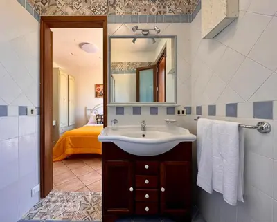 a bathroom with a sink and a mirror at Camere da Mariolina in Macari