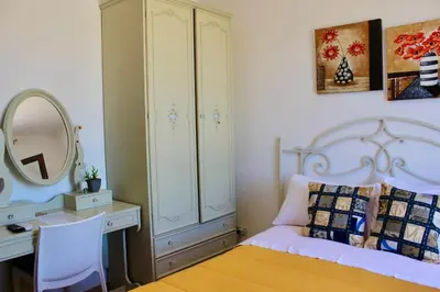 a bedroom with a bed and a dresser and a mirror at Camere da Mariolina in Macari