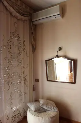 a room with a curtain and a mirror and a stool at B&B Pisani in Palermo