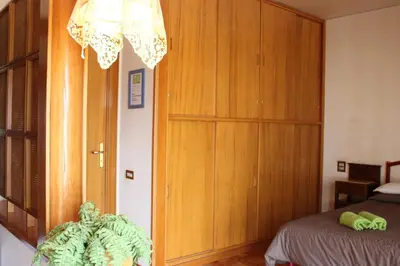 a bedroom with a bed and a wooden cabinet at B&B Pisani in Palermo