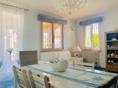 a dining room with a table and a chandelier at Villa Camelie in Campofelice di Roccella