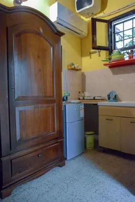 a kitchen with a large wooden cabinet and a refrigerator at Millimetro in Palermo