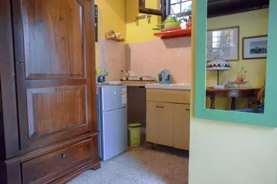 a kitchen with a wooden door and a white refrigerator at Millimetro in Palermo