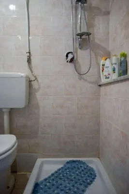 a bathroom with a shower and a toilet and a blue rug at Millimetro in Palermo