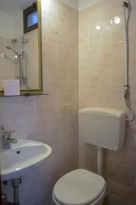 a bathroom with a white toilet and a sink at Millimetro in Palermo