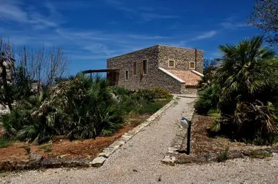 a stone house with a pathway leading to it at Villa Firriato in San Vito lo Capo