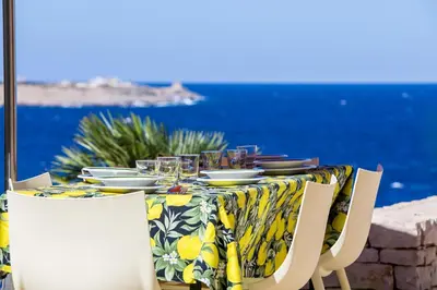 a table with plates and glasses on top of it at Villa Firriato in San Vito lo Capo