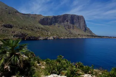 a view of a blue lake with a mountain at Villa Firriato in San Vito lo Capo