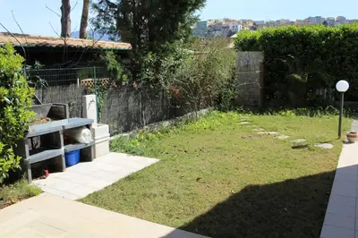 a backyard with a yard with a fence and a field at Casa Vacanze Roccella Beach in Campofelice di Roccella