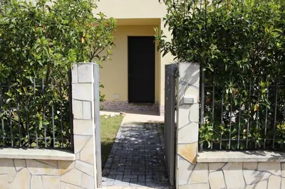 an entrance to a house with a gate with a tree at Casa Vacanze Roccella Beach in Campofelice di Roccella