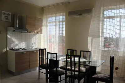a kitchen with a glass table and some chairs at Casa Timpanella in Partinico