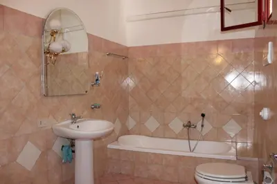 a bathroom with a sink and a tub and a toilet at Casa Timpanella in Partinico