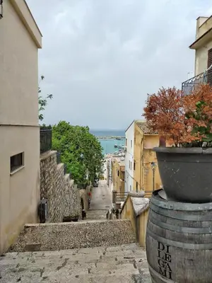 an alley with a pot on the side of a building at Casa vacanza Nicuzza in Castellammare del Golfo
