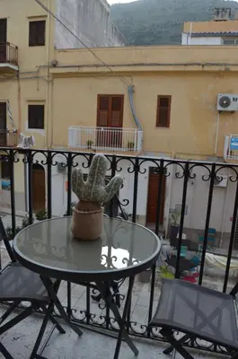 a table with a cactus sitting on top of a balcony at Casa vacanza Nicuzza in Castellammare del Golfo