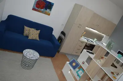 a living room with a blue couch and a table at Casa vacanza Nicuzza in Castellammare del Golfo