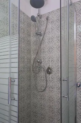 a shower in a bathroom with a tile wall at Piccola Oasi in Mondello