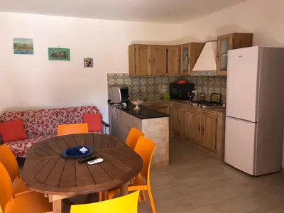 a kitchen with a table and a kitchen with a refrigerator at Appartamenti Cala Azzurra in Scopello