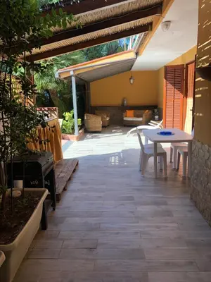 an outdoor patio with a table and a table and chairs at Appartamenti Cala Azzurra in Scopello
