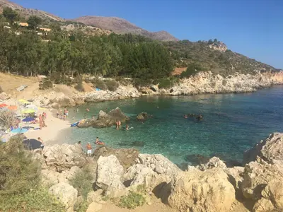 a group of people in the water at a beach at Appartamenti Cala Azzurra in Scopello
