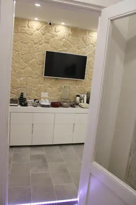 a kitchen with a tv on the wall at Ri.Mo's Rent Room in Palermo