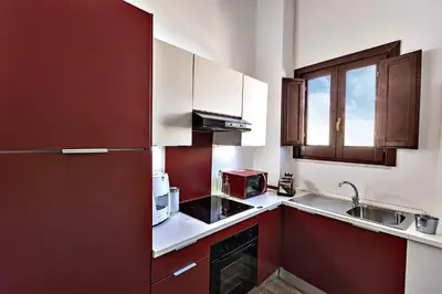 a kitchen with red and white cabinets and a sink at Casa Nostra B&B in Palermo