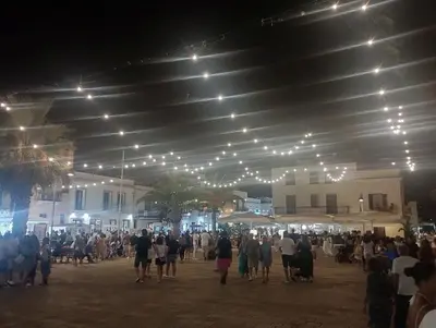 a crowd of people walking under a building at night at holiday home LG in San Vito lo Capo