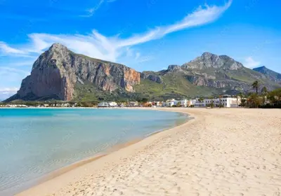 a beach with a mountain in the background stock photo at holiday home LG in San Vito lo Capo