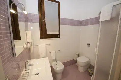 a bathroom with a sink and a toilet and a mirror at B&B Coppola in Castelluzzo