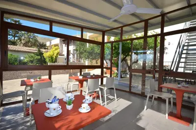 a restaurant with tables and chairs and large windows at B&B Coppola in Castelluzzo