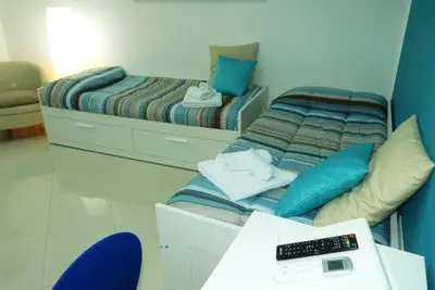 a room with two beds and a desk with a scale at Casa Principe Maqueda in Palermo