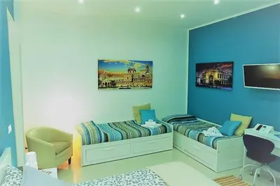 a room with two beds and a desk in it at Casa Principe Maqueda in Palermo