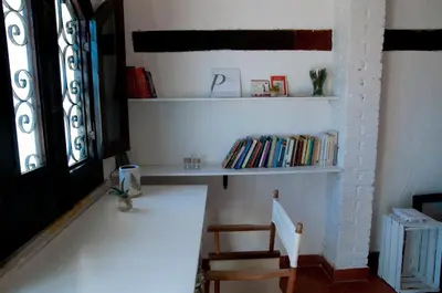 a room with a shelf with books and a chair at Addumari in Palermo