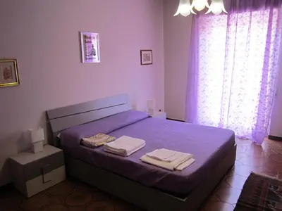 a bedroom with a purple bed with towels on it at Appartamento Vacanza Luna in Partinico