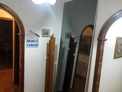 a hallway with two mirrors and a sign on a wall at Appartamento Vacanza Luna in Partinico