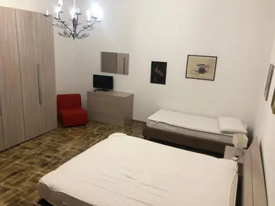 a hospital room with two beds and a red chair at Appartamento Vacanza Luna in Partinico