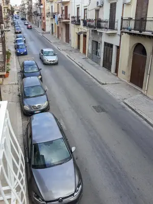 a group of cars parked on the side of a street at White in Castellammare del Golfo
