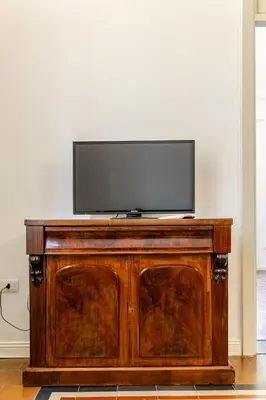 a flat screen tv sitting on top of a wooden cabinet at Bilocale in Centro in Palermo