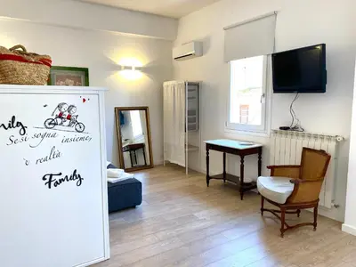 a living room with a table and a tv at Residence Le Rose in Castellammare del Golfo