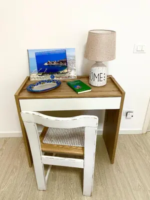 a desk with a chair and a lamp on it at Residence Le Rose in Castellammare del Golfo