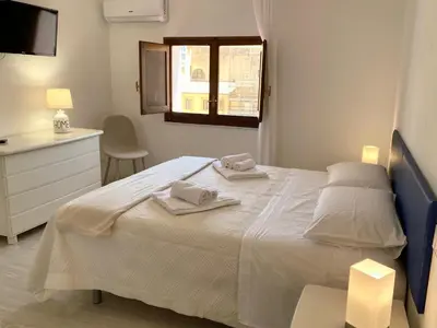 a bedroom with a white bed with towels on it at Residence Le Rose in Castellammare del Golfo