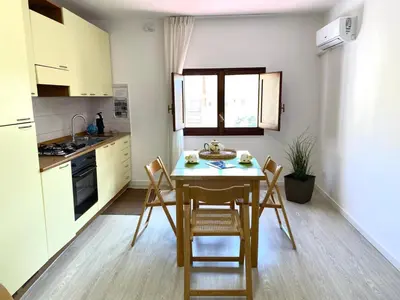 a kitchen with a table and chairs in a room at Residence Le Rose in Castellammare del Golfo