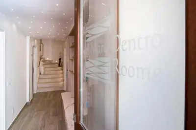 a hallway with a glass door leading to a staircase at Il Mare Dentro Rooms in San Vito lo Capo