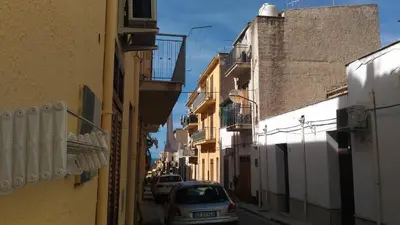 a car parked on a narrow street with buildings at Appartamenti La Stella in Castellammare del Golfo