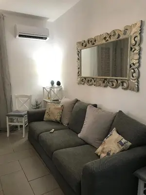 a living room with a couch and a mirror at Holiday & House - Imparato Vacanze Prestige Mondello in Mondello