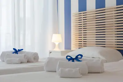 a bedroom with white towels with blue bows on them at Zammù in Palermo