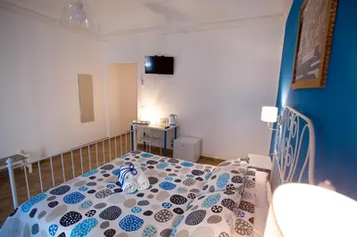 a bedroom with a bed with a blue and white comforter at Quattro Incanti in Palermo
