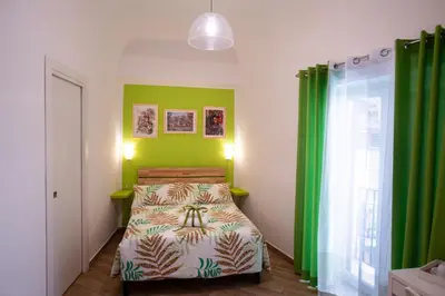 a bedroom with green walls and a bed in a room at Quattro Incanti in Palermo