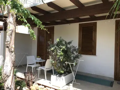 a patio with a table and chairs and a tree at Cima Bianca in San Vito lo Capo