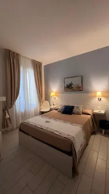 a bedroom with a large bed and a window at Cima Bianca in San Vito lo Capo