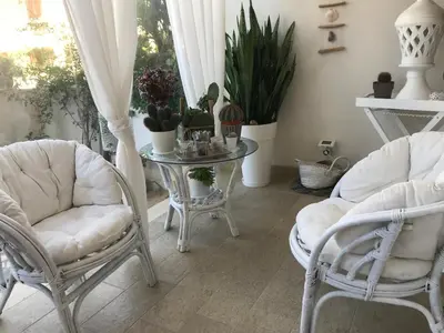 a room with two chairs and a table with plants at Cima Bianca in San Vito lo Capo